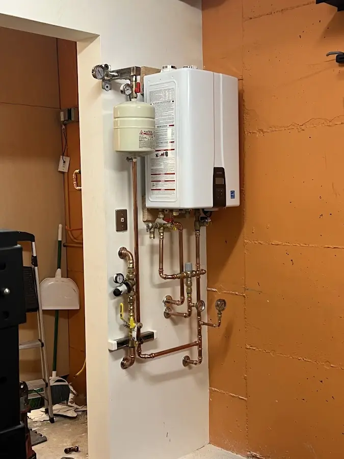 Plumbing technician inspecting water heater connections in Mount Airy